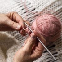 high-view-person-knitting-with-pink-thread